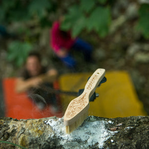 The Pongoose Climber 700 shown as a brushing stick brushing a chalky bouldering hold.